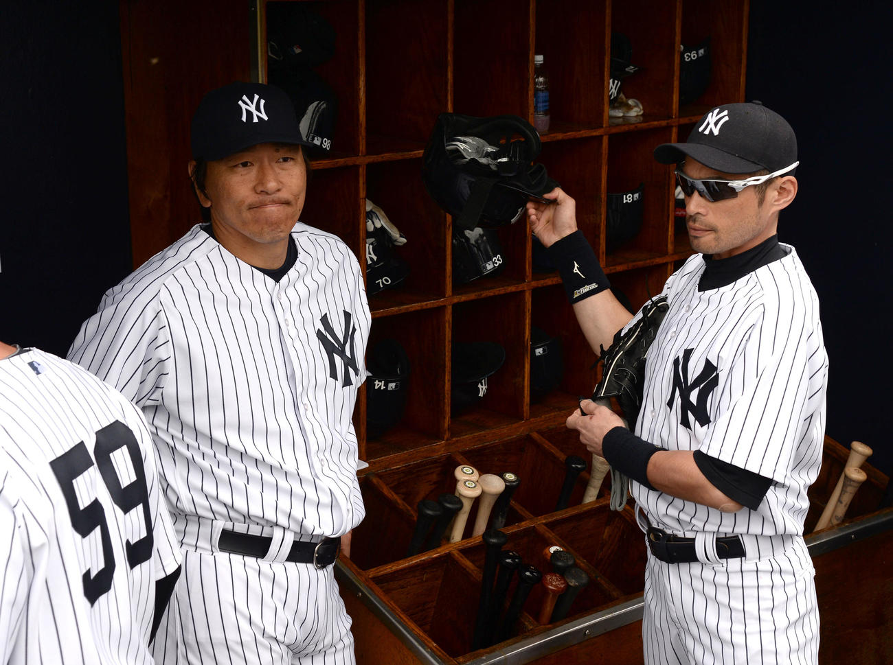 ピンストライプのユニホーム姿でベンチに入った松井臨時コーチ。右はイチロー（2014年2月27日）