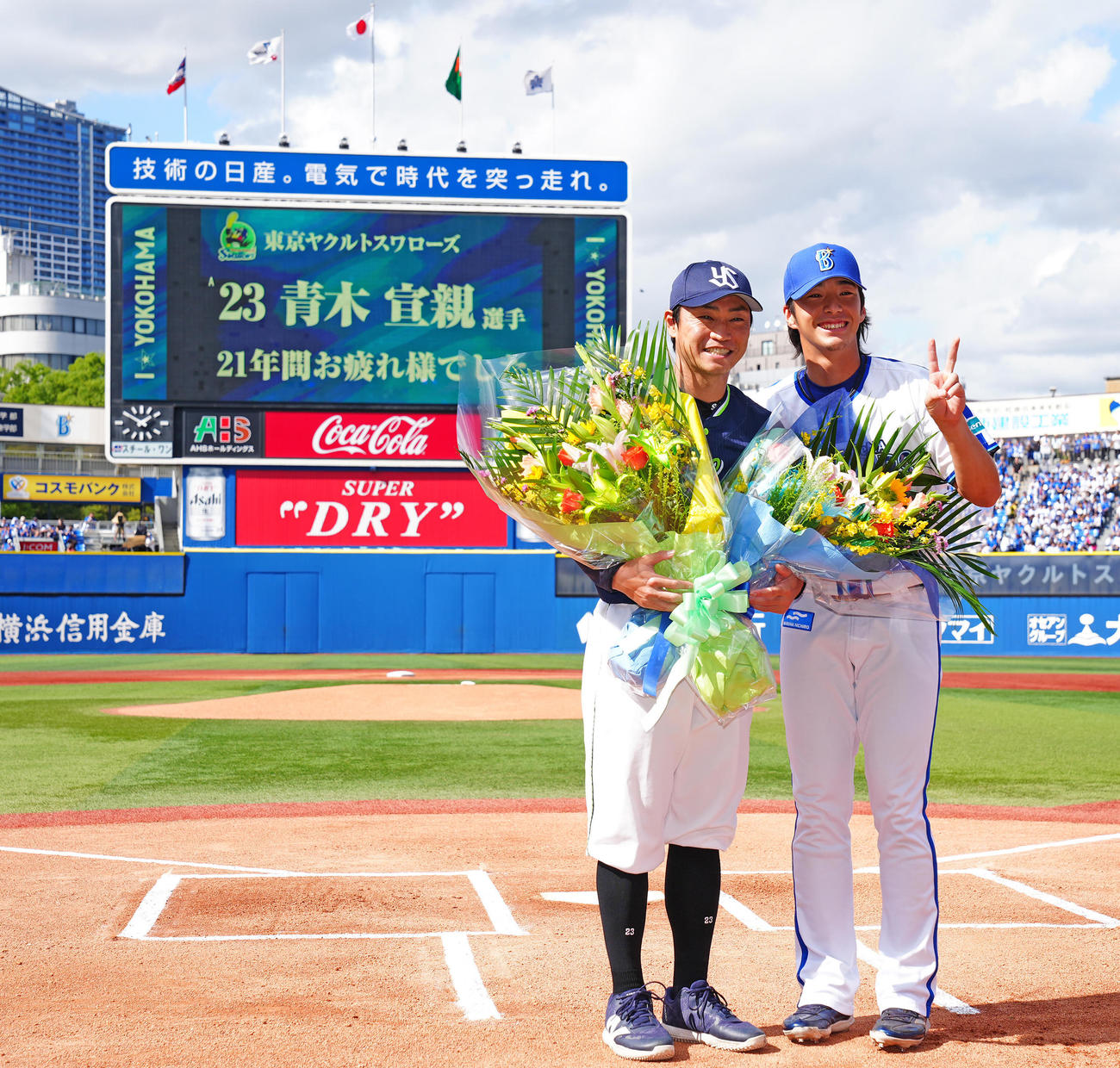 DeNA対ヤクルト　試合前、DeNA度会（右）から花束を受け取り写真に納まるヤクルト青木（撮影・垰建太）