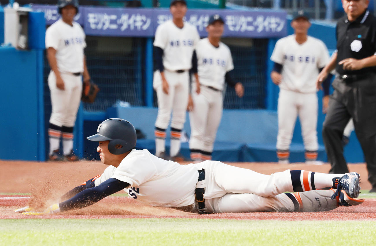 法大対立大　8回表法大1死一、二塁、左中間に2点適時三塁打を放ちヘッドスライディングする篠木（撮影・野上伸悟）