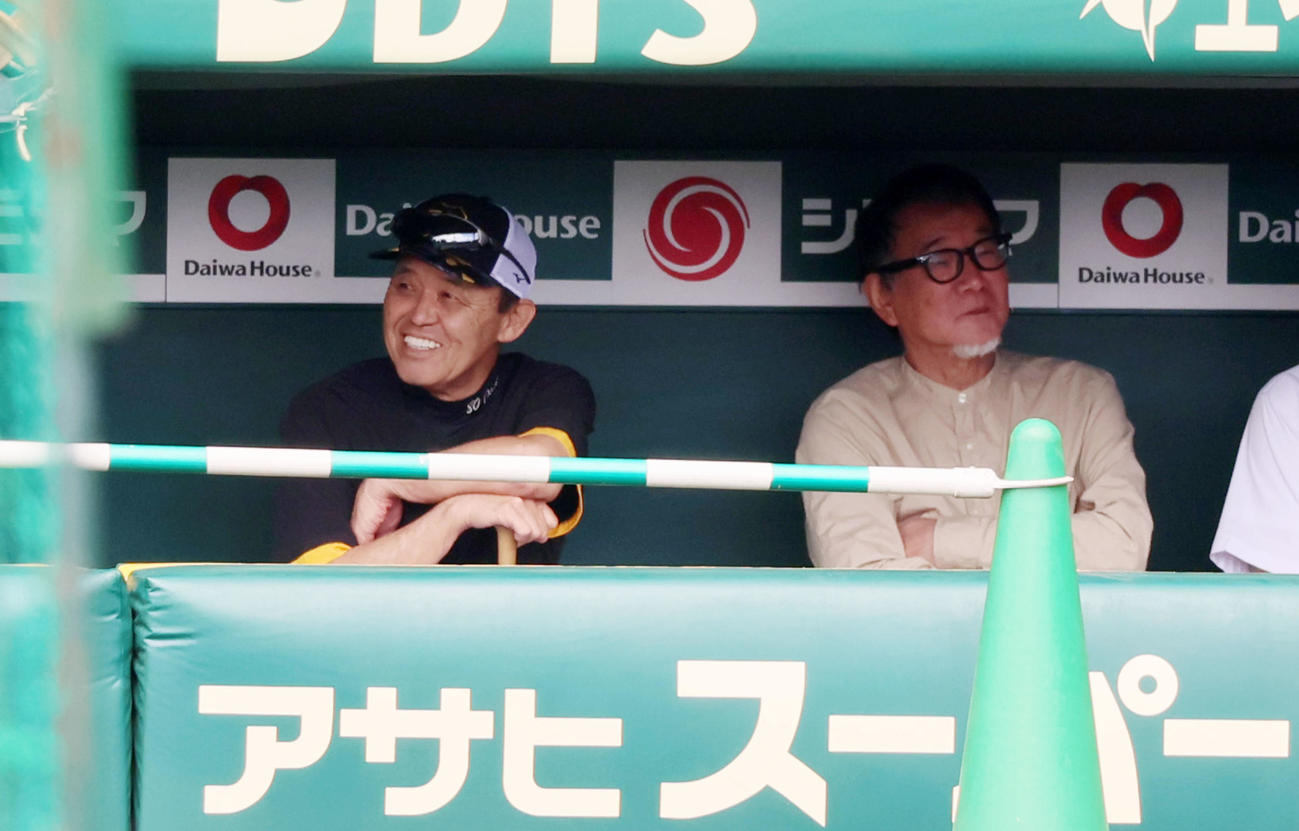 阪神対巨人　練習時にベンチで岡田監督（左）と話すフリーライターの内匠宏幸氏（撮影・加藤哉）