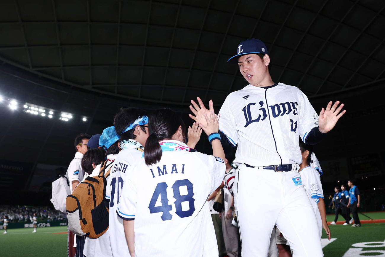 西武対日本ハム　日本ハムに勝利し、子どもたちとタッチを交わしながら引き揚げる武内（撮影・河田真司）