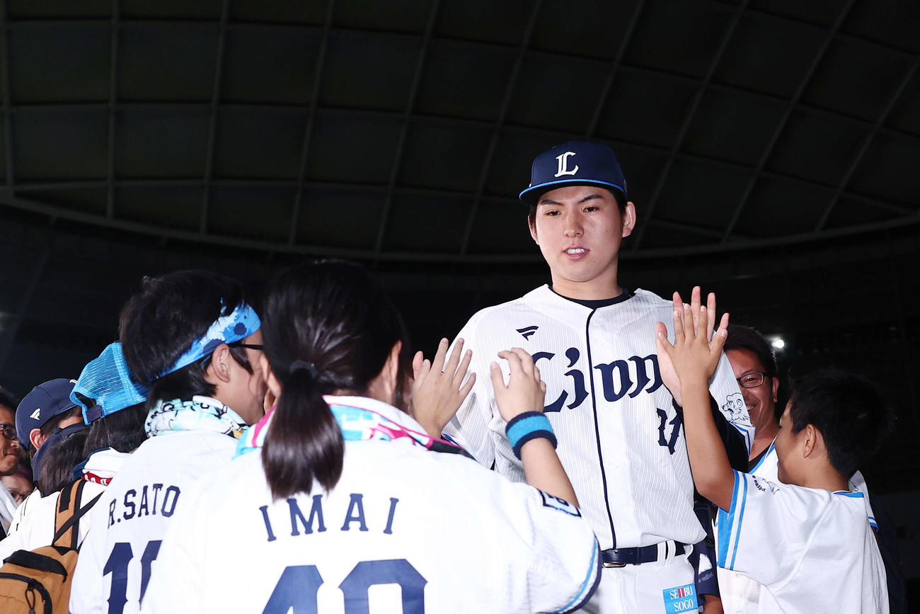西武対日本ハム　日本ハムに勝利し、子どもたちとタッチを交わしながら引き揚げる武内（撮影・河田真司）