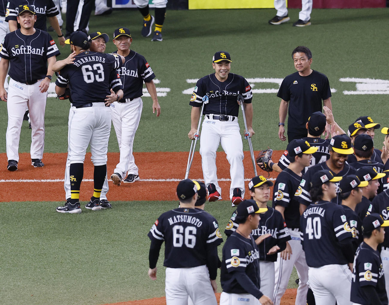 オリックス対ソフトバンク　松葉づえをついてソフトバンク近藤（中央）はリーグ優勝を喜ぶチームメートの元へ急ぐ（撮影・藤尾明華）