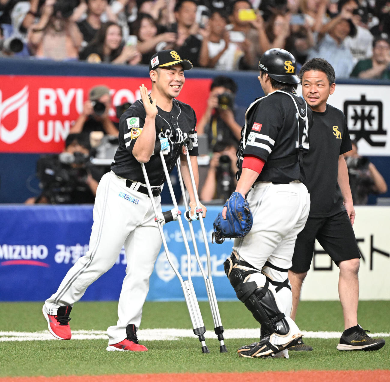 オリックス対ソフトバンク　松葉杖つきながら甲斐拓也（右）とタッチする近藤（撮影・和賀正仁）