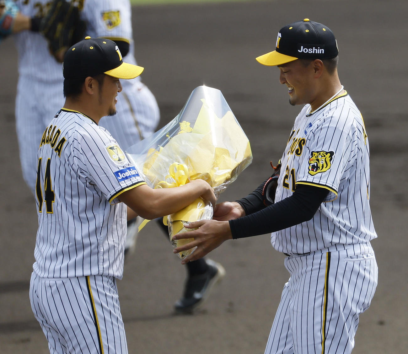 ウエスタンリーグ　阪神対ソフトバンク　現役最後の登板を終え、岩貞（左）から花束を受け取る阪神秋山（撮影・藤尾明華）