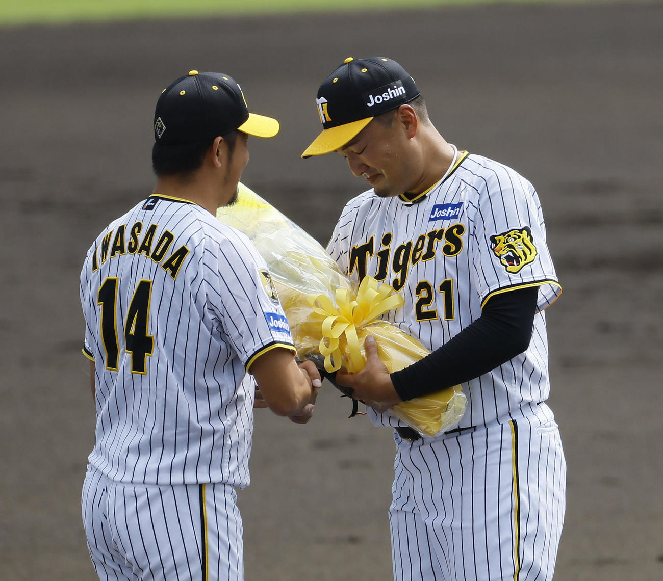 ウエスタンリーグ　阪神対ソフトバンク　現役最後の登板を終え、岩貞祐太（左）から花束を受け取る阪神秋山（撮影・藤尾明華）