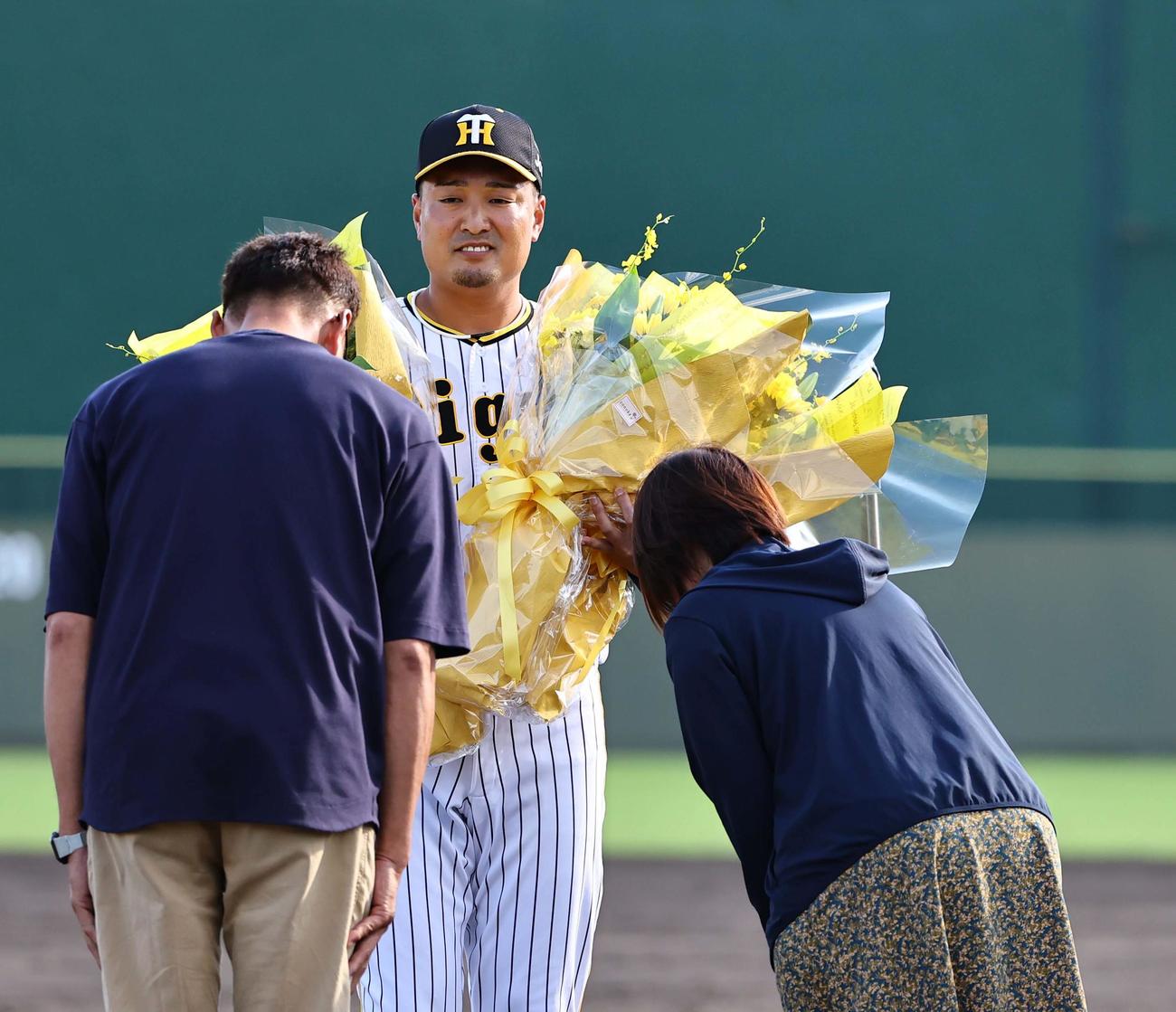 今シーズンで引退する秋山は両親から花束を受け取る（撮影・上田博志）