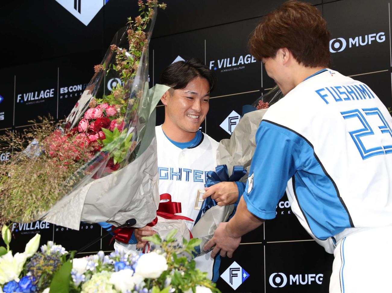 引退会見で伏見から花束を受け取る日本ハム鍵谷（撮影・黒川智章）