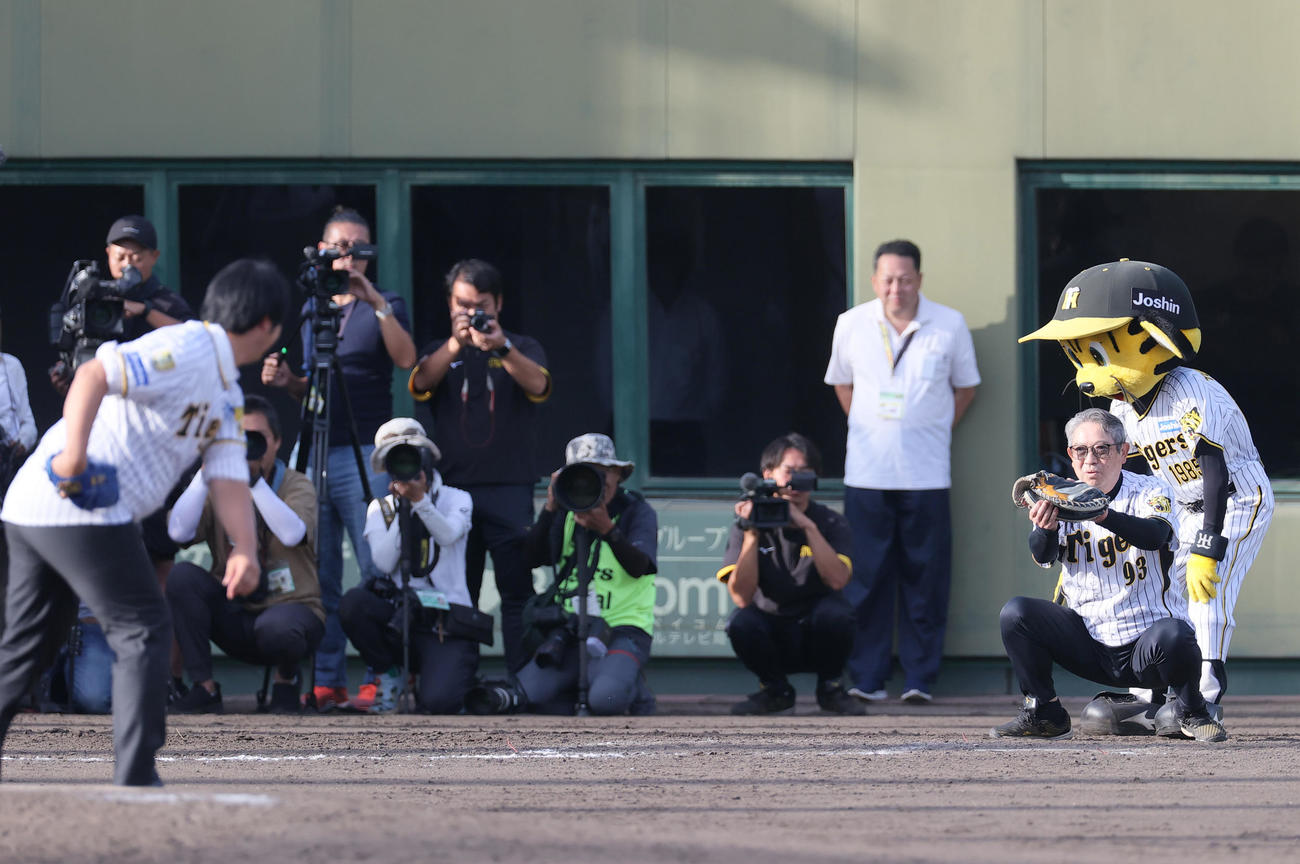 阪神2軍本拠地の鳴尾浜球場でファイナルピッチする阪神OB井川氏（左端）の球を受ける虎風荘の西口副寮長（撮影・上山淳一）