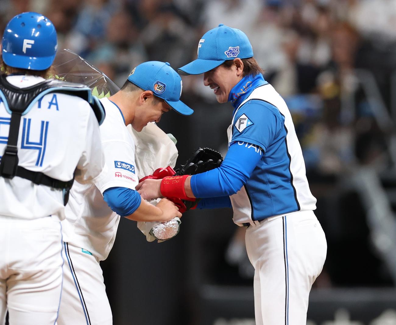日本ハム対楽天　1回表、鍵谷に花束を渡す新庄監督（撮影・黒川智章）