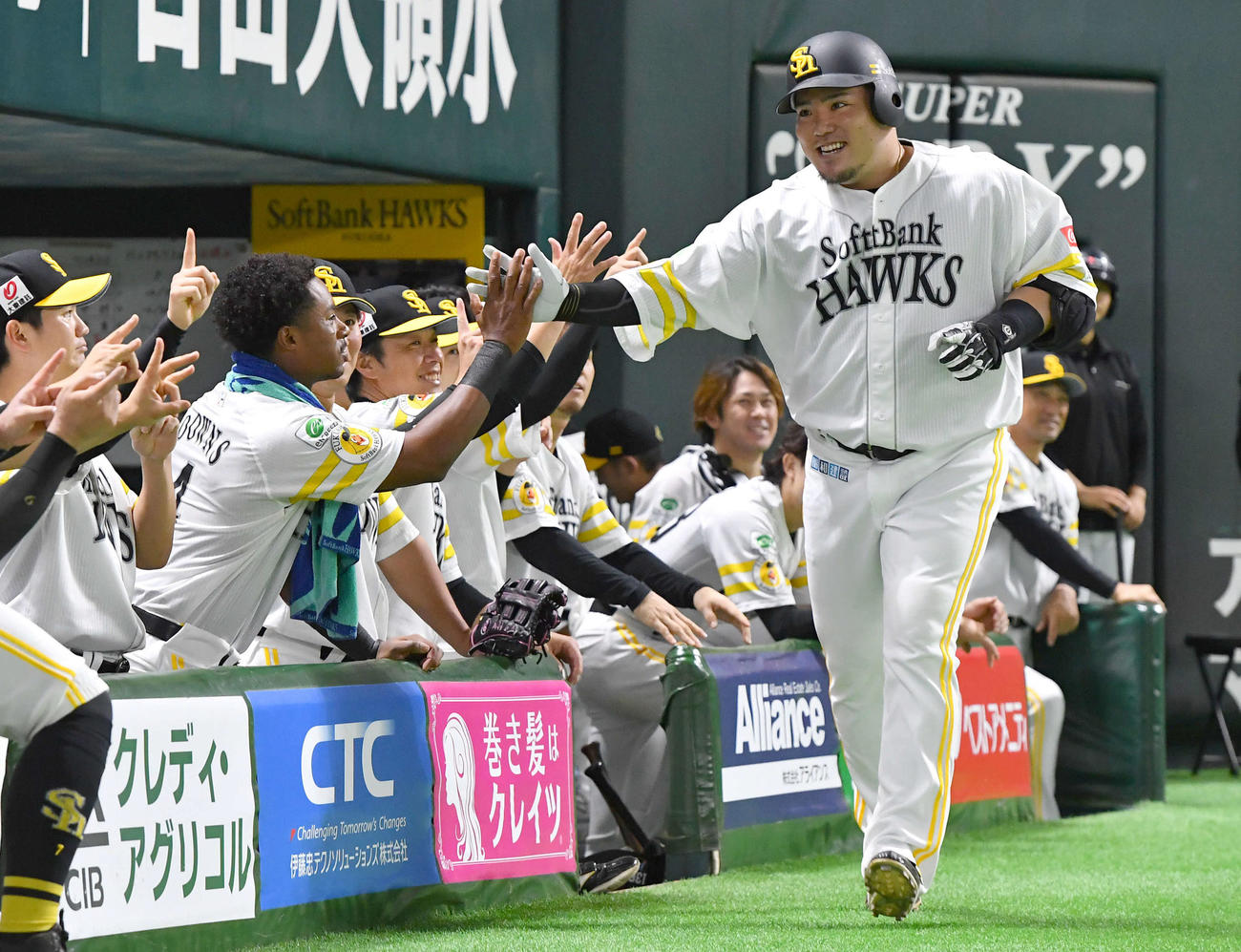 ソフトバンク対西武　4回裏ソフトバンク2死、先制の左越え本塁打を放ち、ダウンズ（左から2人目）らナインと笑顔でタッチを交わす山川（撮影・岩下翔太）