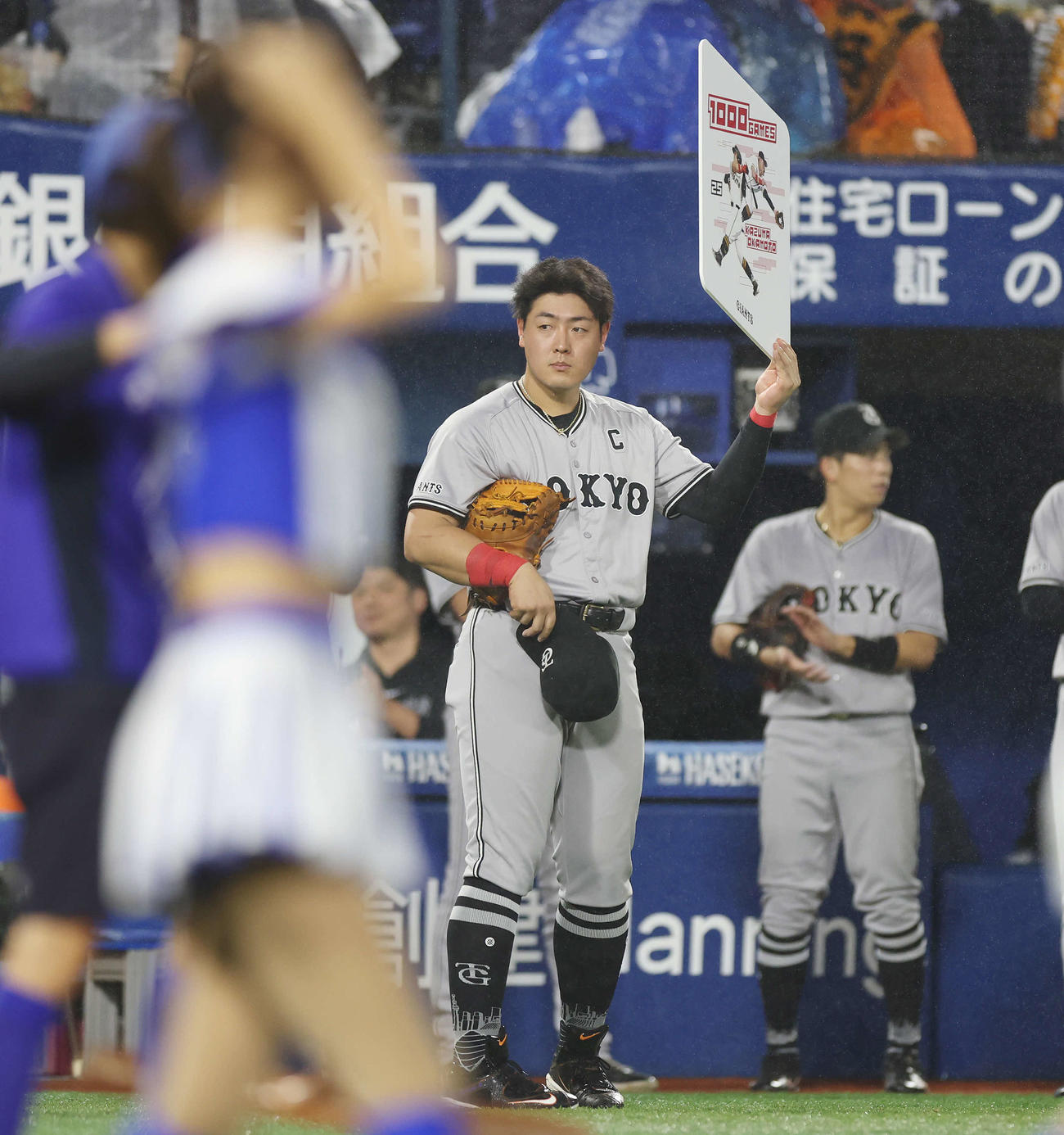 DeNA対巨人　5回裏を終え、通算1000試合出場を達成し記念ボードを掲げる巨人岡本和（撮影・宮地輝）