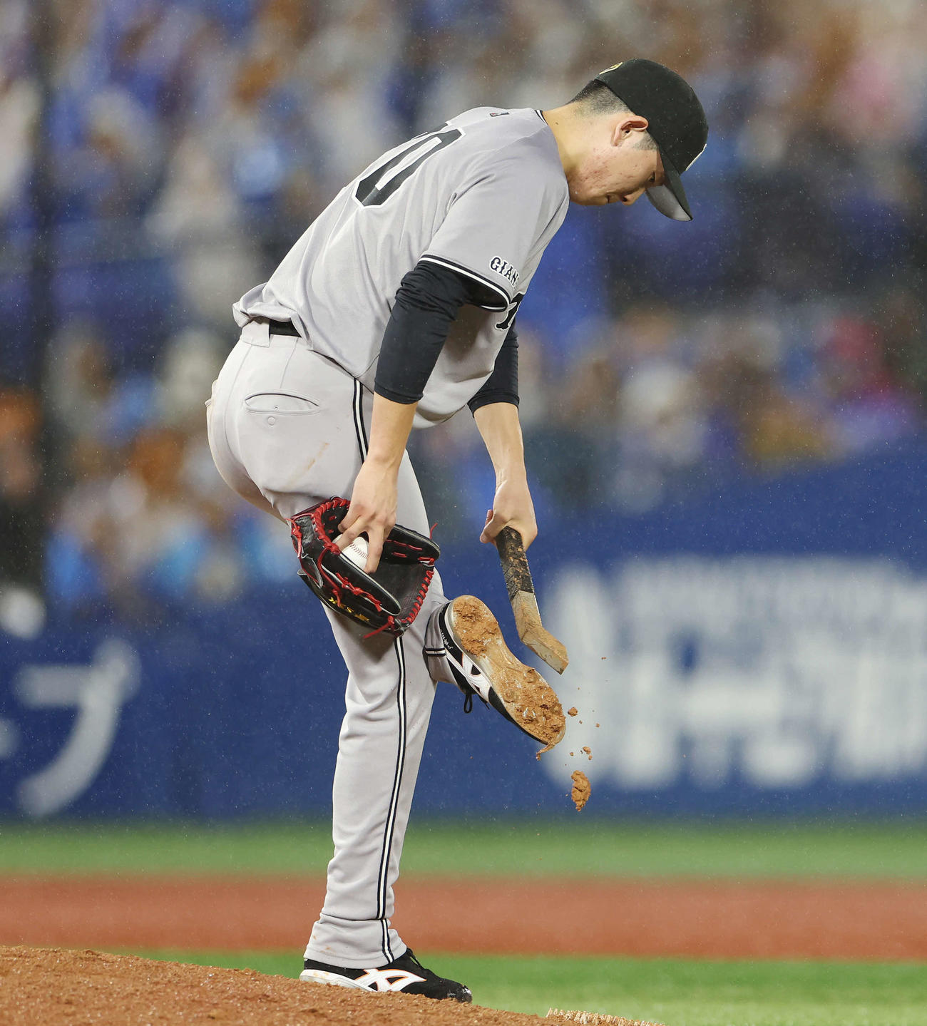 DeNA対巨人　スパイクに付いた土をたたき落とす巨人戸郷（撮影・宮地輝）