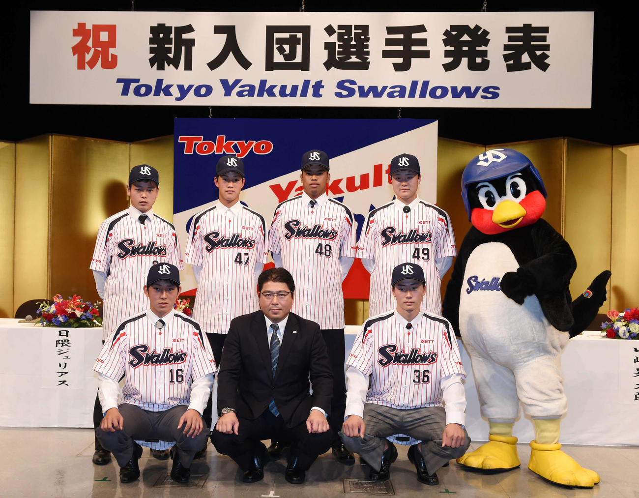 2015年12月、新入団選手発表で記念写真に納まる選手たち。前列左から原、真中監督、広岡、後列左から山崎、高橋、日隈、渡辺、つば九郎