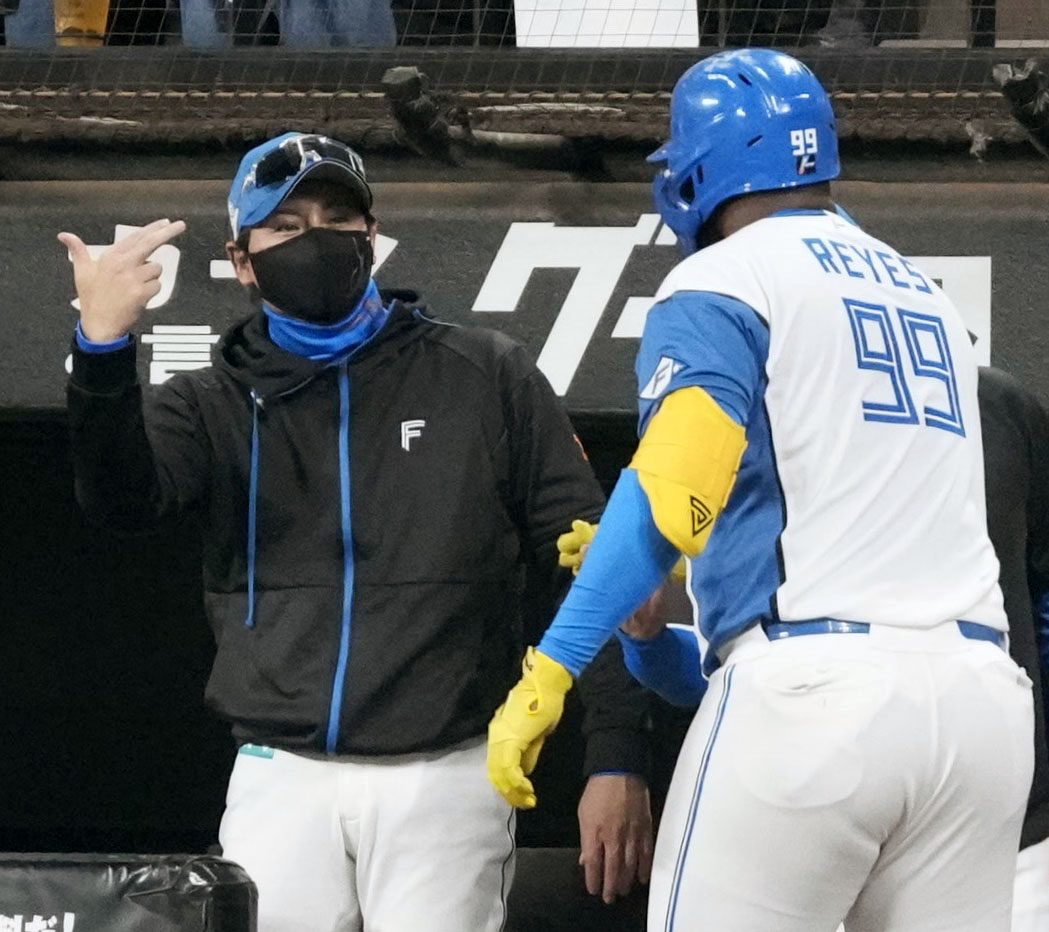 4回、本塁打を放ったレイエス（右）を迎える日本ハム・新庄監督(共同)