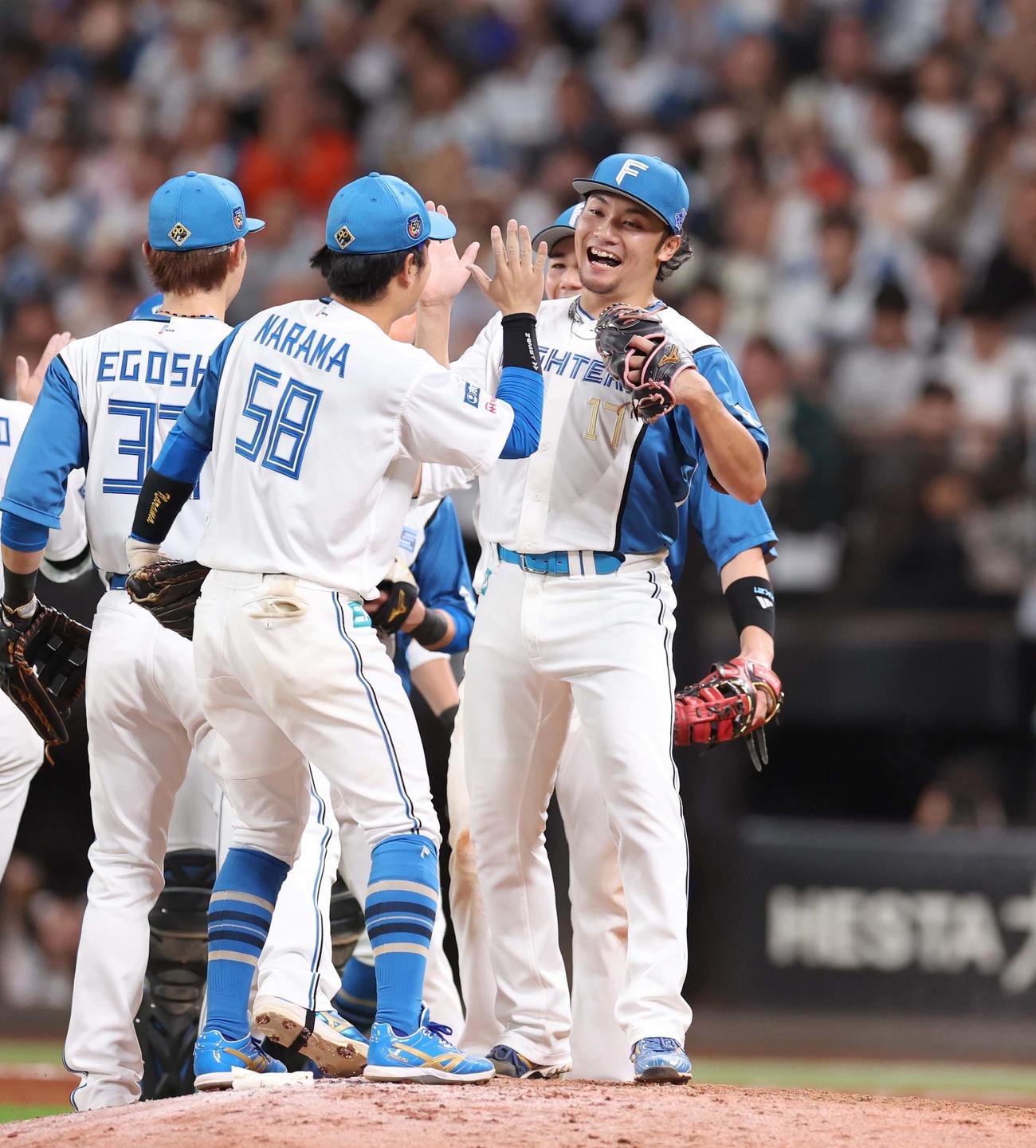 日本ハム対楽天　14勝目を挙げチームメートと笑顔でハイタッチする日本ハム伊藤（撮影・黒川智章）