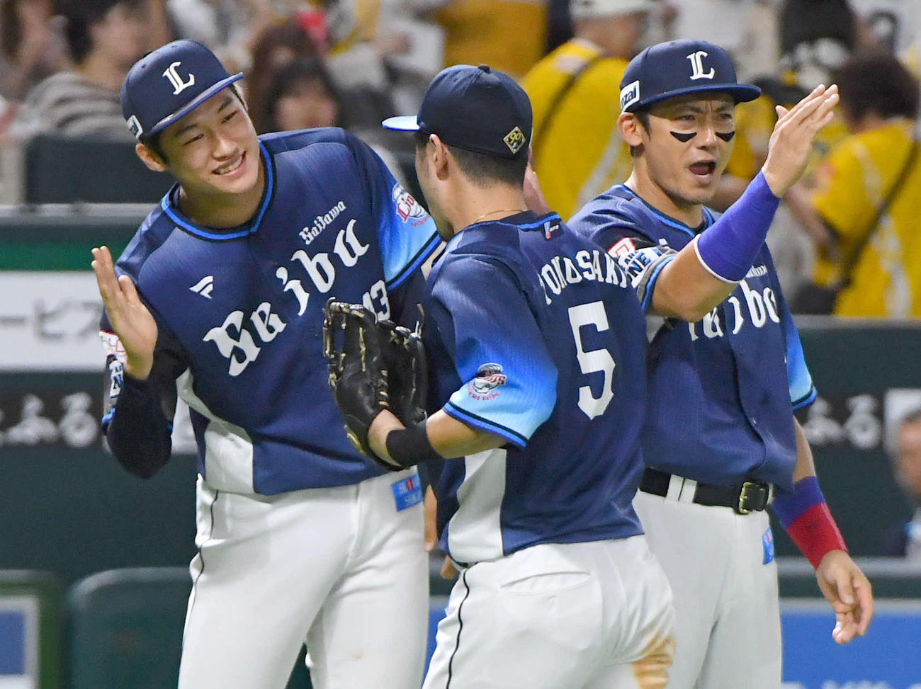 ソフトバンク対西武　ソフトバンクに勝利し、外崎（中央）らナインとタッチを交わす羽田（左）と栗山（撮影・岩下翔太）