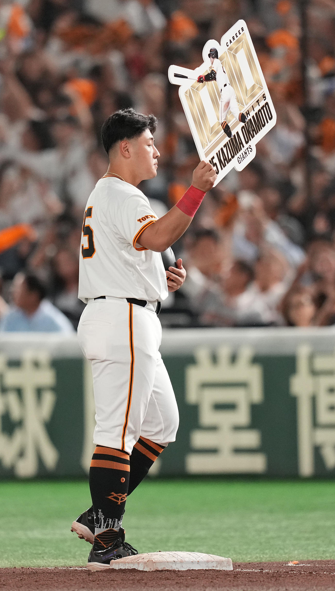 巨人対中日　6回裏巨人無死一、三塁、プロ通算1000安打となる先制の中前適時打を放った岡本和はボードを掲げる（撮影・鈴木みどり）