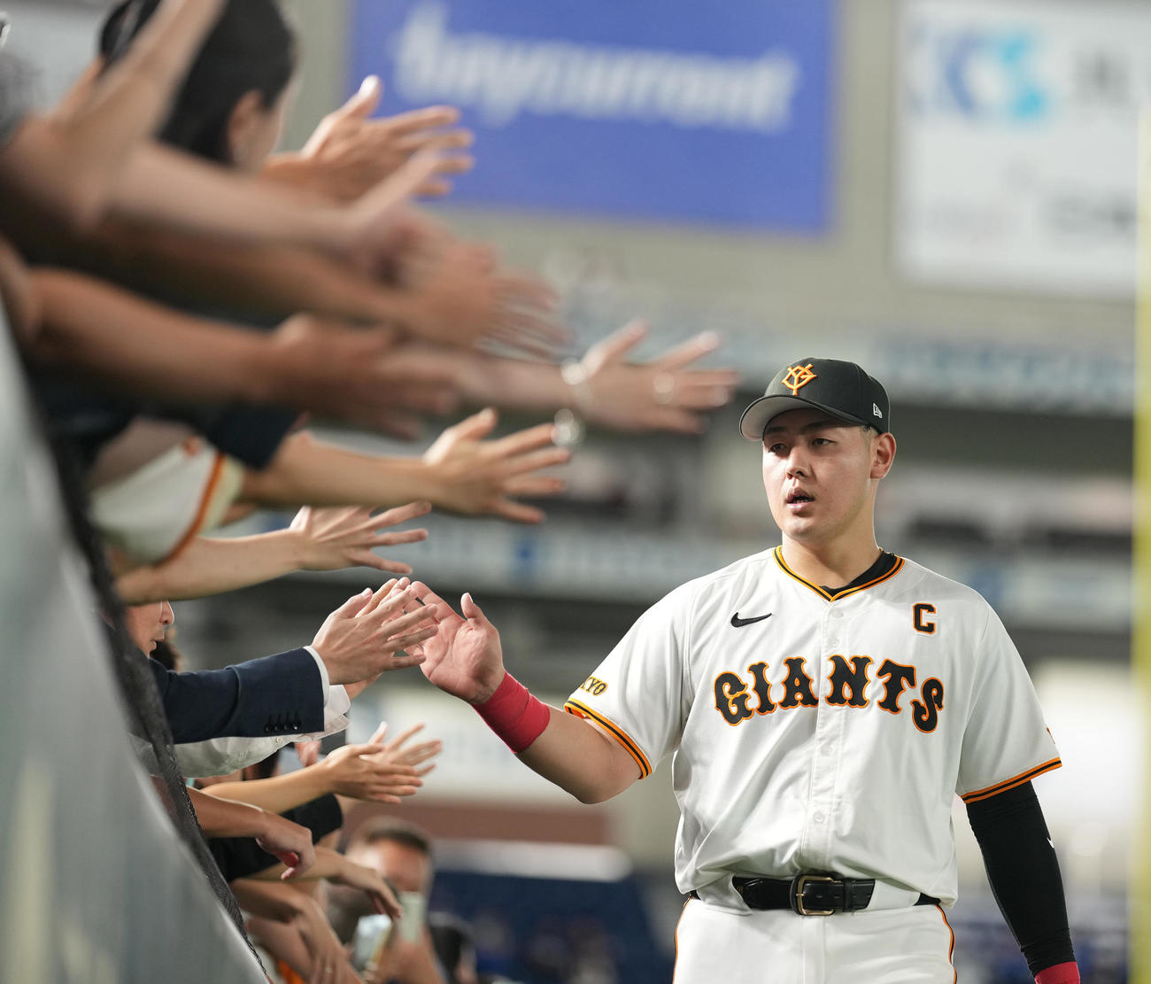 巨人対中日　中日に勝利し、ファンとハイタッチする巨人岡本和（撮影・鈴木みどり）