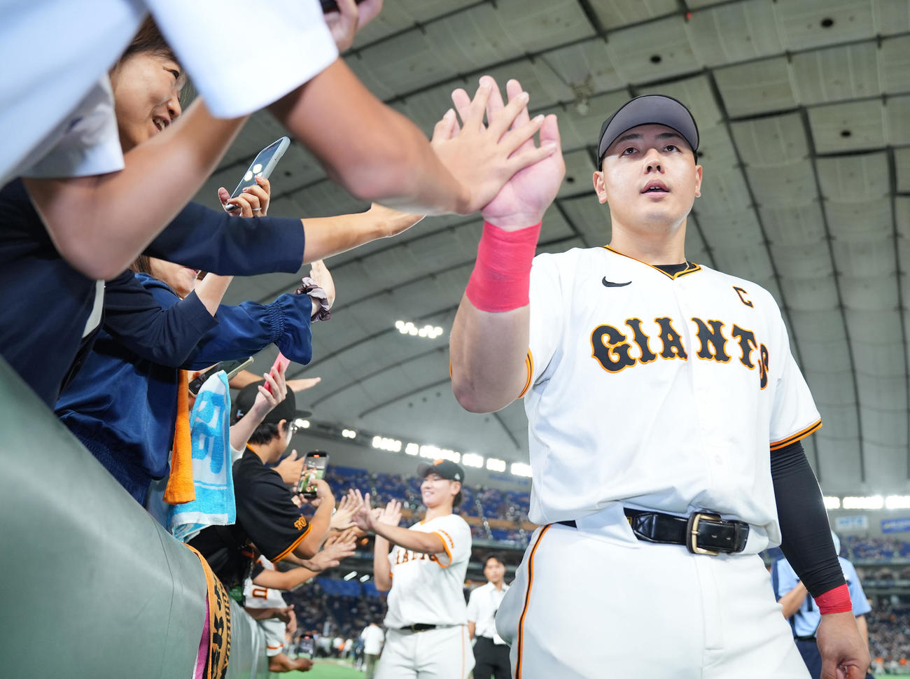 巨人対中日　中日に勝利しファンとタッチを交わす巨人岡本和（撮影・垰建太）