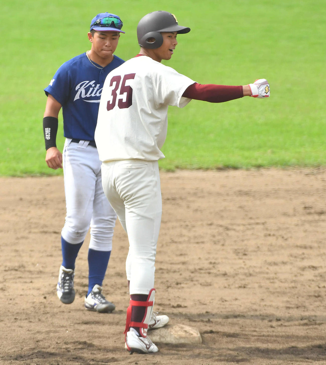 北九大対福岡大　5回裏福岡大無死、中二塁打で出塁し、ベンチに向かってガッツポーズする山下（撮影・岩下翔太）