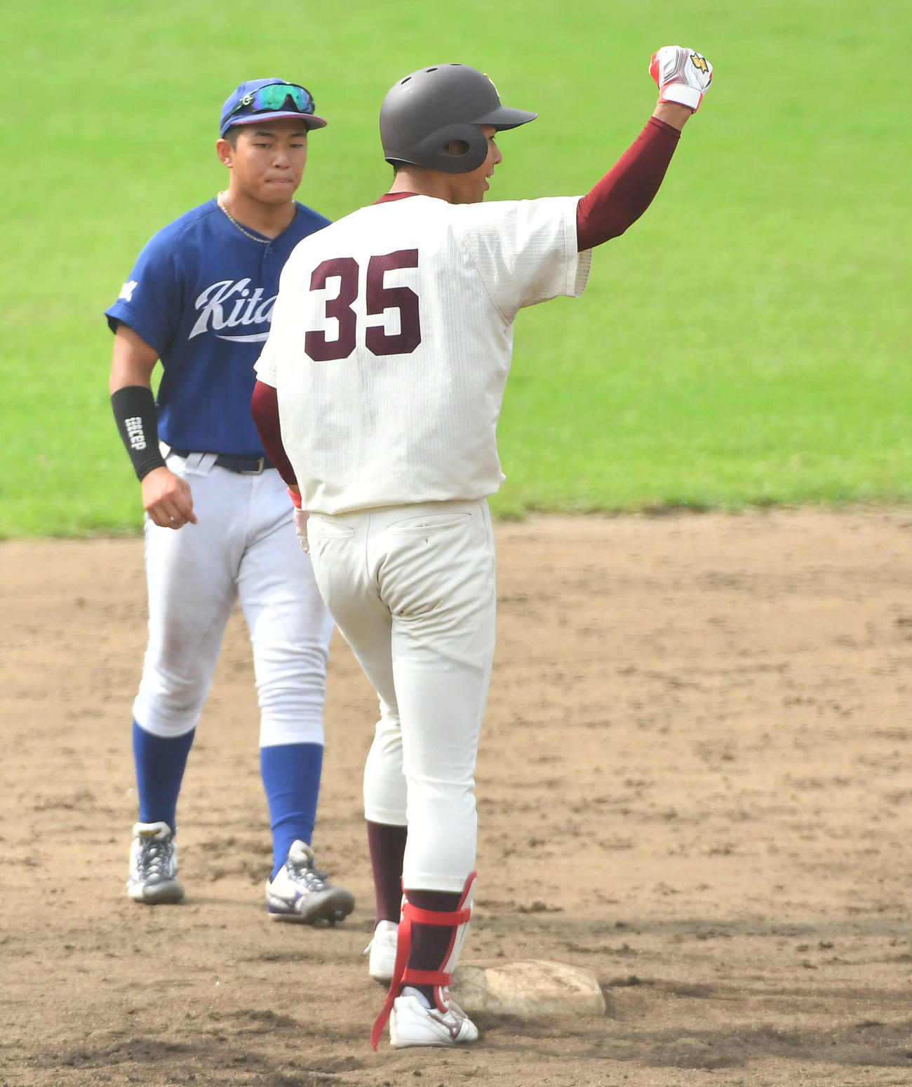 北九大対福岡大　5回裏福岡大無死、中二塁打で出塁し、ベンチに向かってガッツポーズする山下（撮影・岩下翔太）