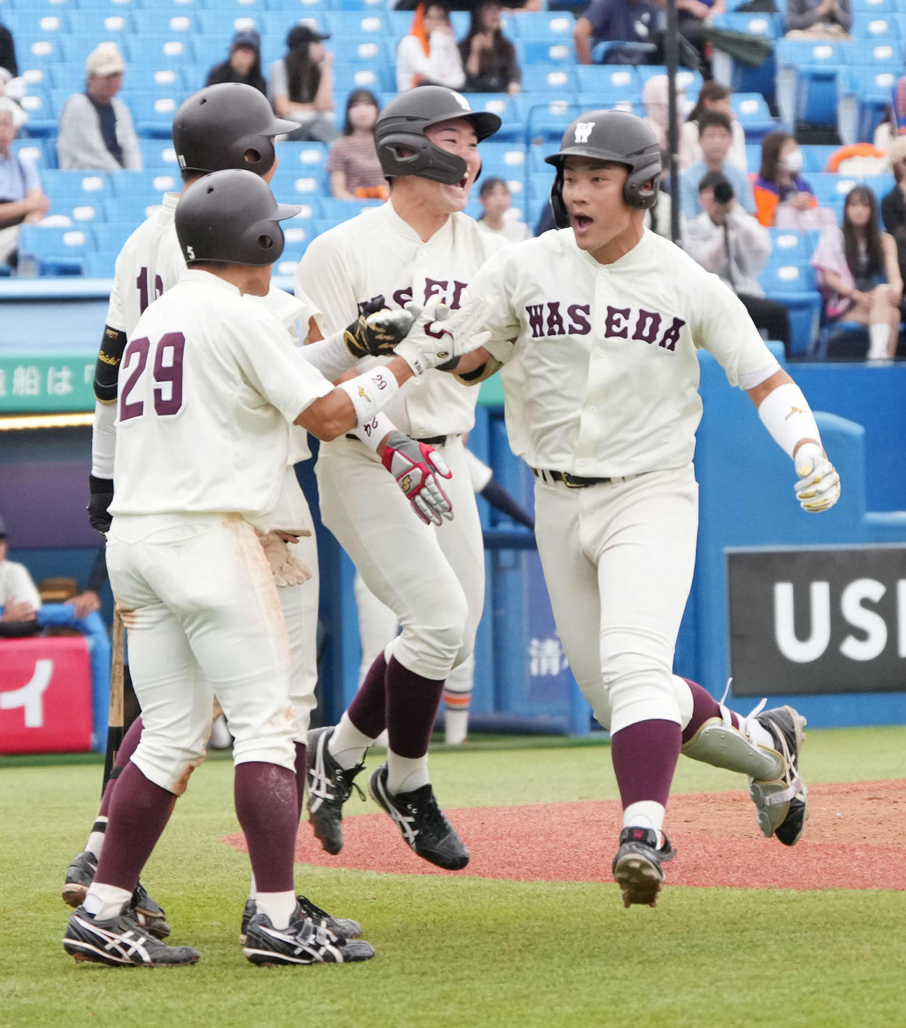 法大対早大　7回裏早大1死一、二塁、吉納（右）は左越えに逆転3点本塁打を放ちナインの祝福を受ける（撮影・小沢裕）