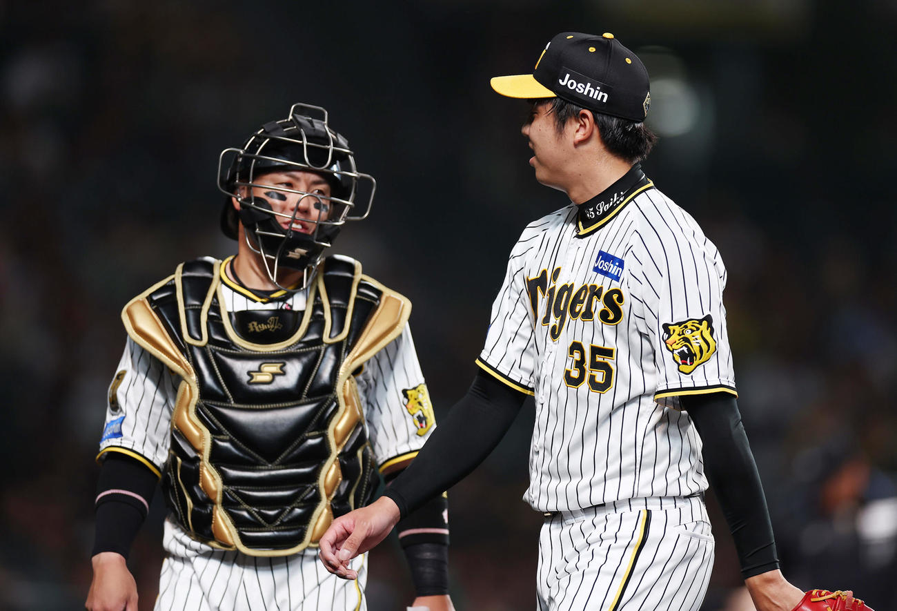阪神対DeNA 1回表を投げ終え、阪神梅野（左）と言葉を交わしながらベンチへ戻る才木（撮影・前田充）