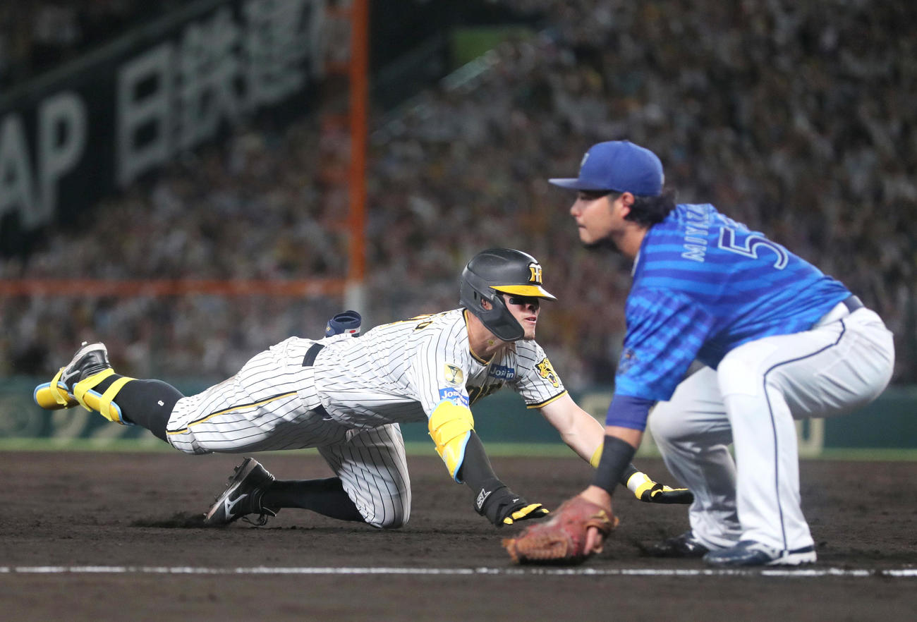 阪神対DeNA 7回裏阪神2死一、二塁、佐藤輝（左）は左2点適時三塁打を放ち三塁に向かう。三塁手宮崎（撮影・上山淳一）
