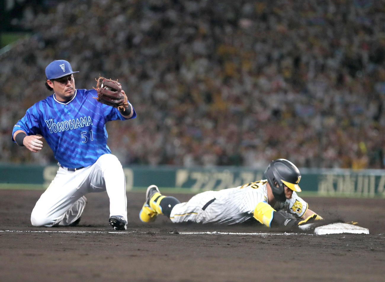 阪神対DeNA 7回裏阪神2死一、二塁、佐藤輝（右）は左2点適時三塁打を放ち三塁に向かう。三塁手宮崎（撮影・上山淳一）