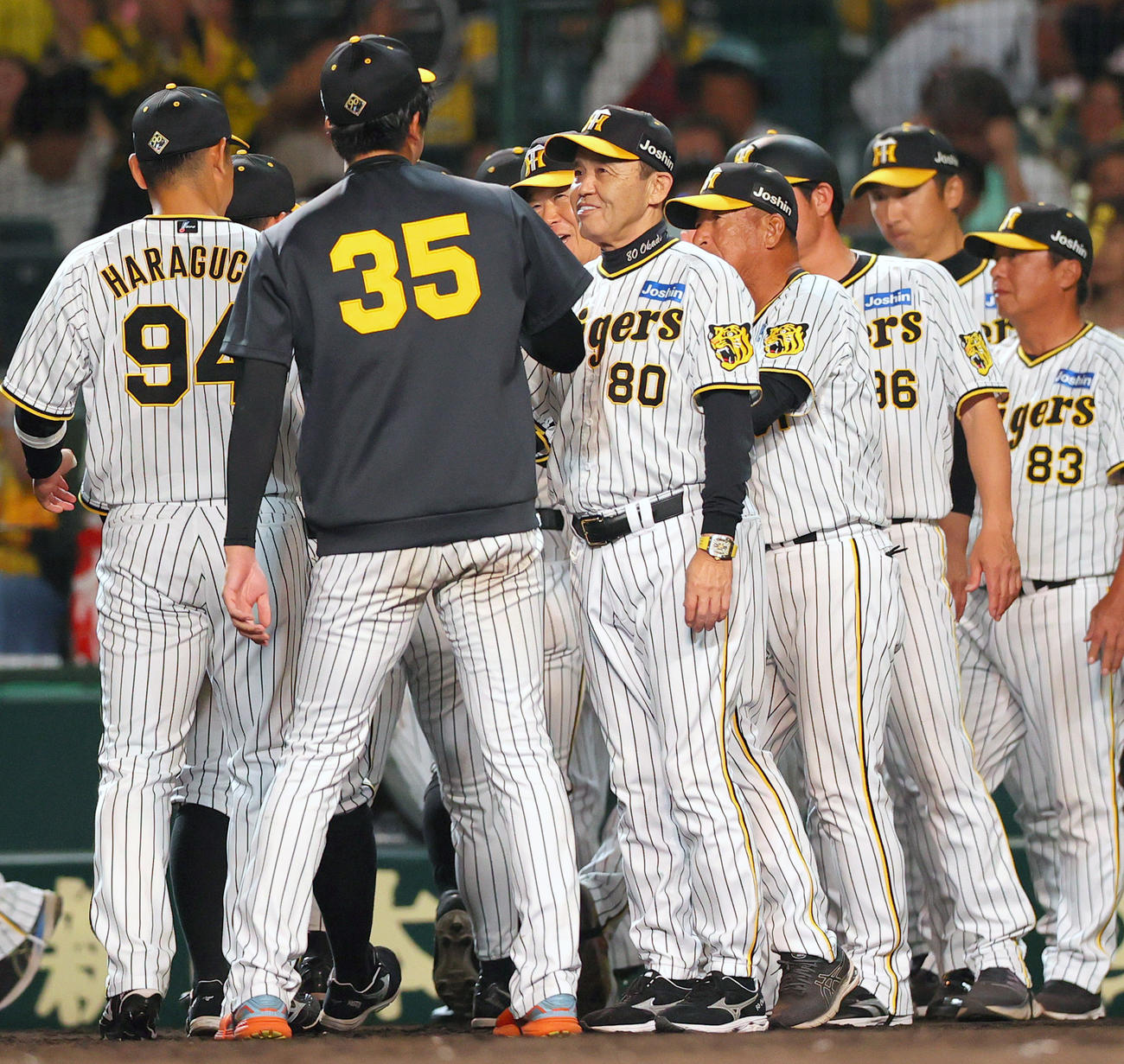 阪神対DeNA DeNAに勝利した阪神岡田監督（左から3人目）は笑顔でナインとタッチをかわす（撮影・上山淳一）