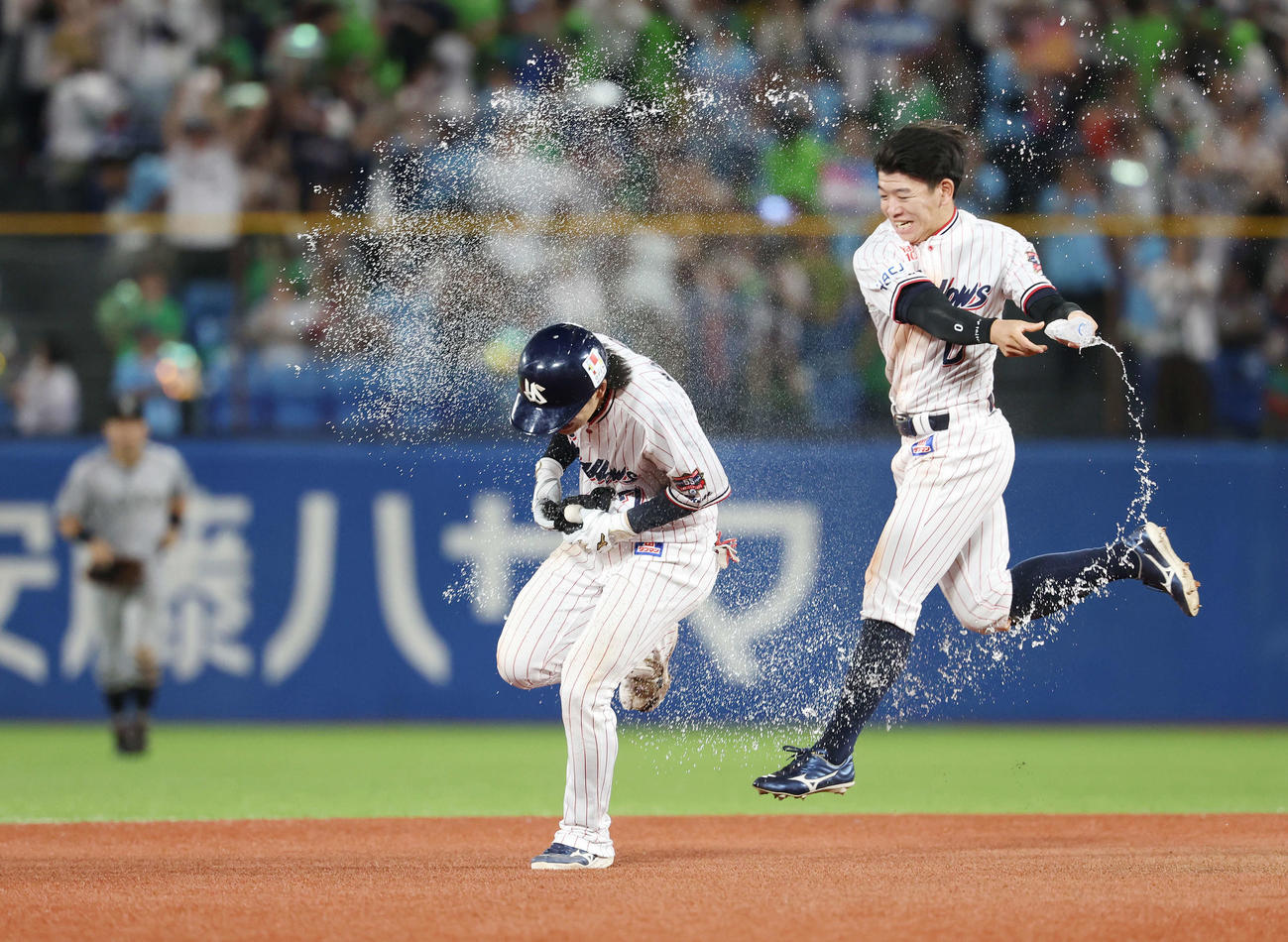 ヤクルト対巨人　9回裏ヤクルト1死一、三塁、右前サヨナラ適時打を放った長岡（左）は並木から祝福のウオーターシャワーを浴びる（撮影・宮地輝）