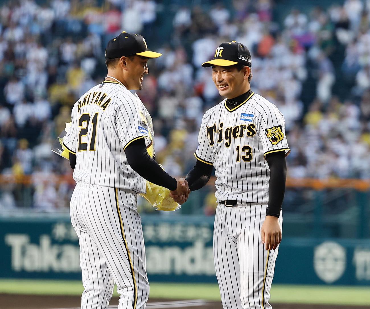 阪神対DeNA　ファイナルピッチャーセレモニーを終え、岩崎（右）から花束を受け取り握手を交わす阪神秋山（撮影・藤尾明華）