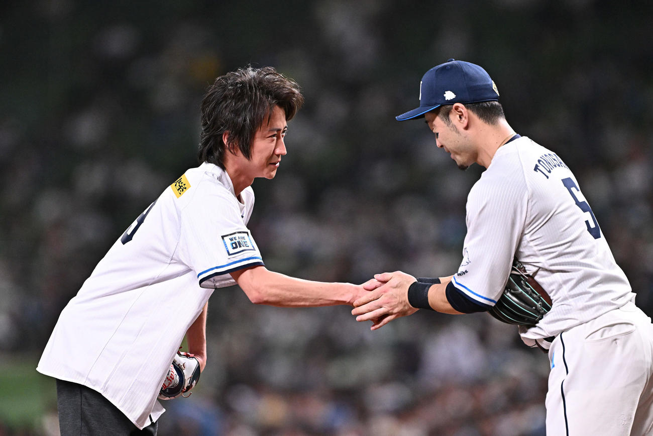 西武対日本ハム　セレモニアルピッチを終えた藤原竜也（左）は西武外崎と握手を交わす（撮影・滝沢徹郎）