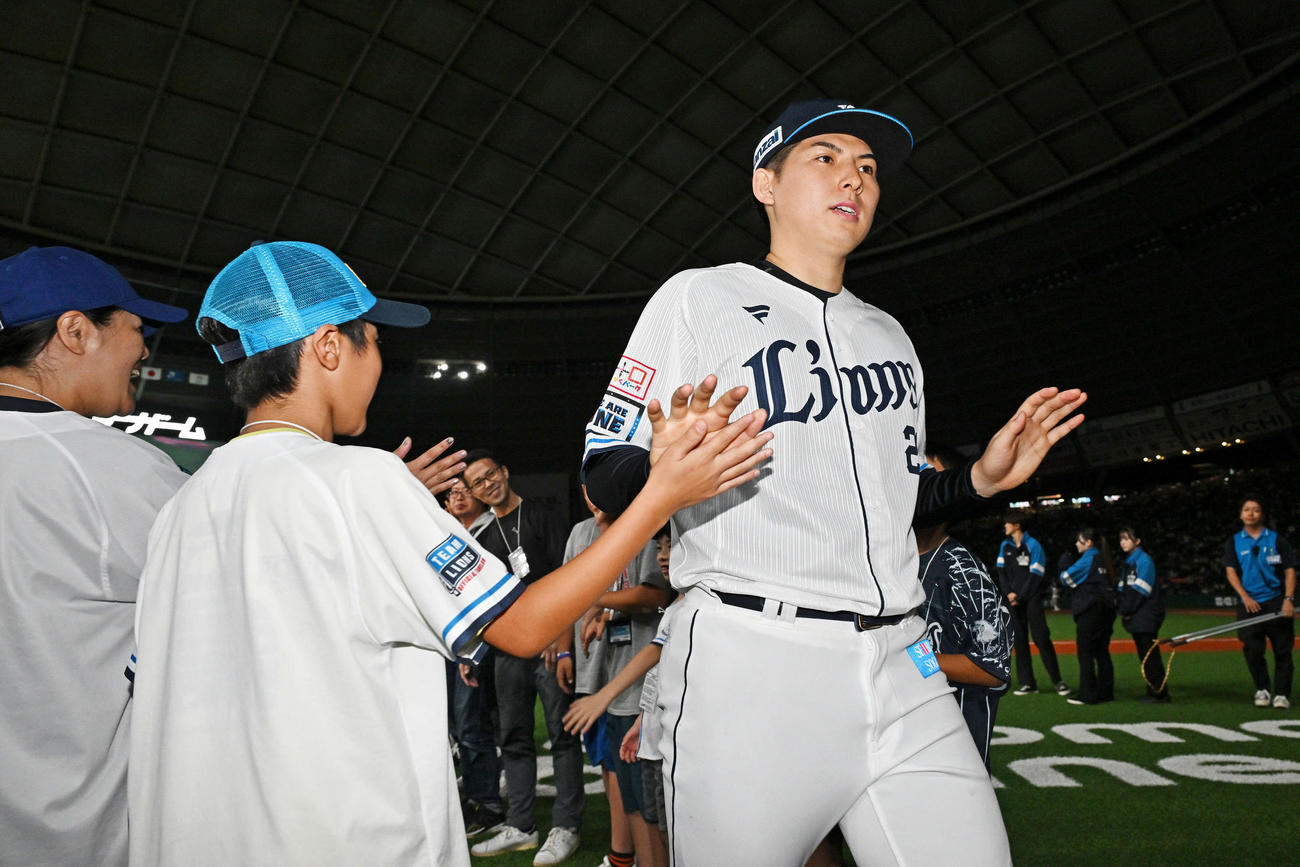 西武対日本ハム　試合後、今季10勝目を挙げた西武武内は子供のファンとタッチをかわす（撮影・滝沢徹郎）