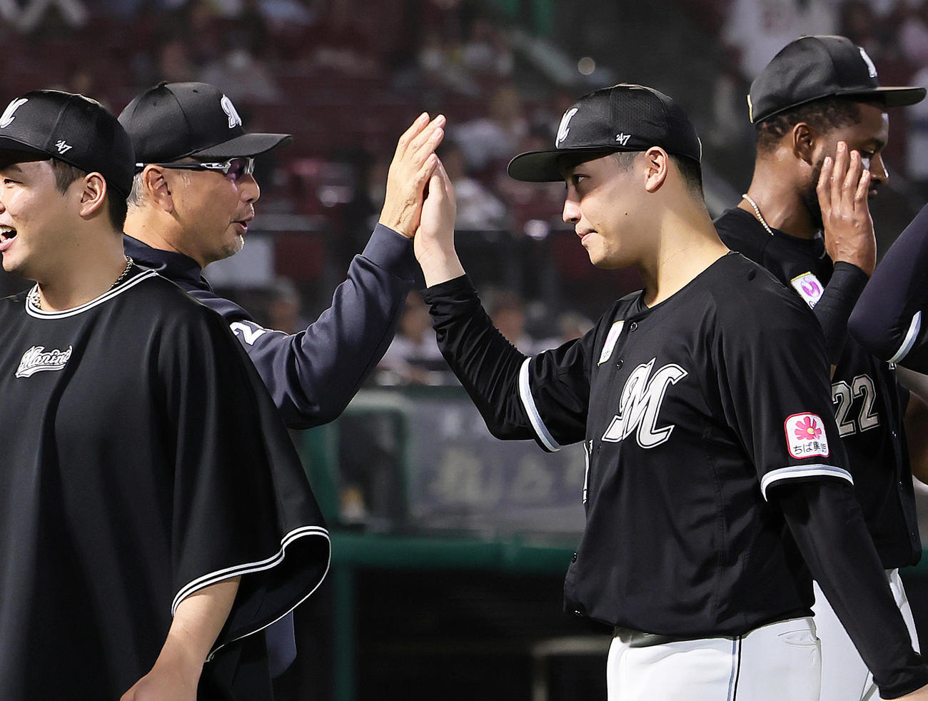 楽天対ロッテ　プロ初勝利を挙げたロッテ菊地（右）は吉井監督とタッチを交わす（撮影・足立雅史）