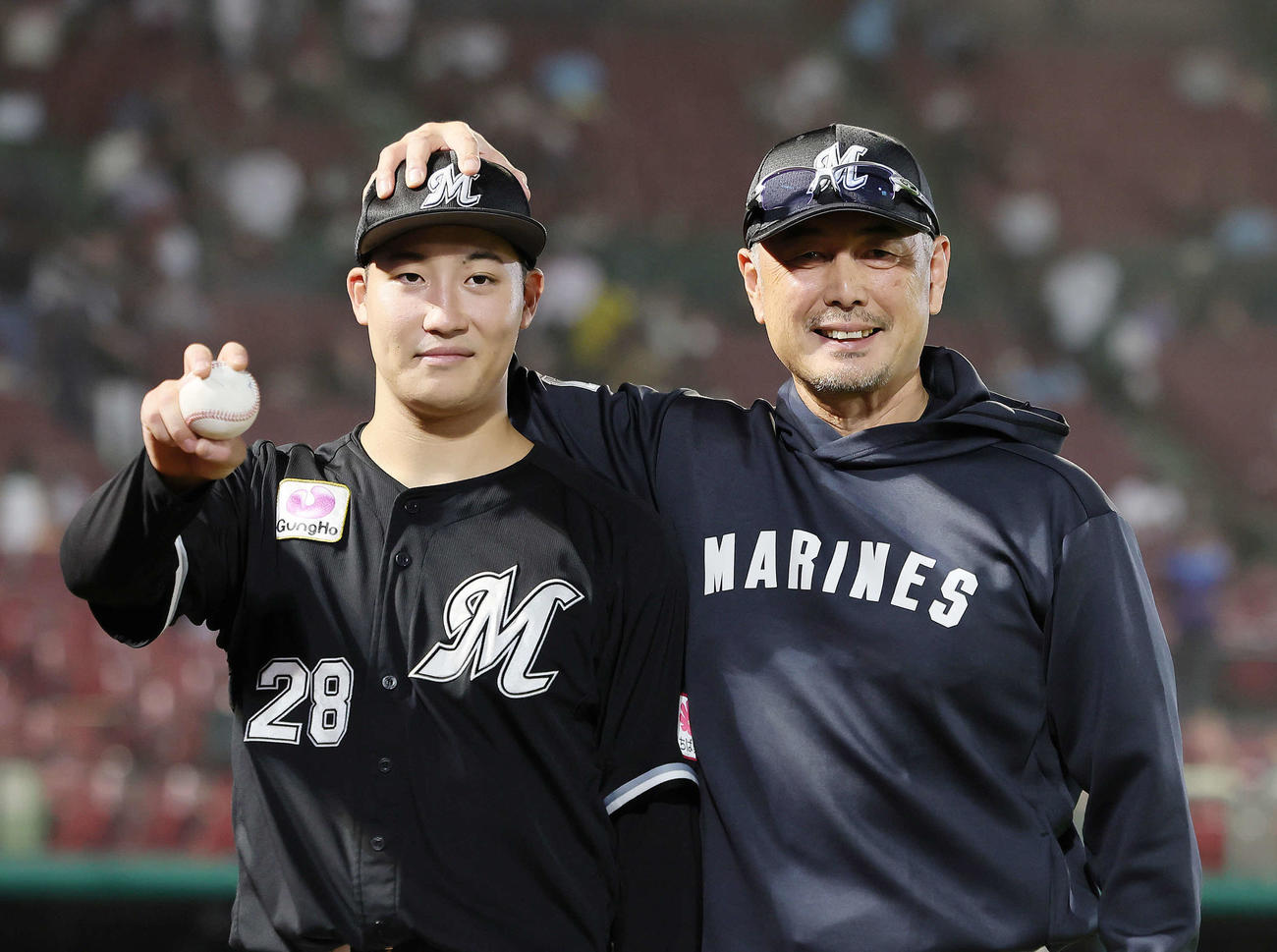楽天対ロッテ　プロ初勝利を挙げたロッテ菊地（左）は記念球を手に吉井監督と笑顔を見せる（撮影・足立雅史）