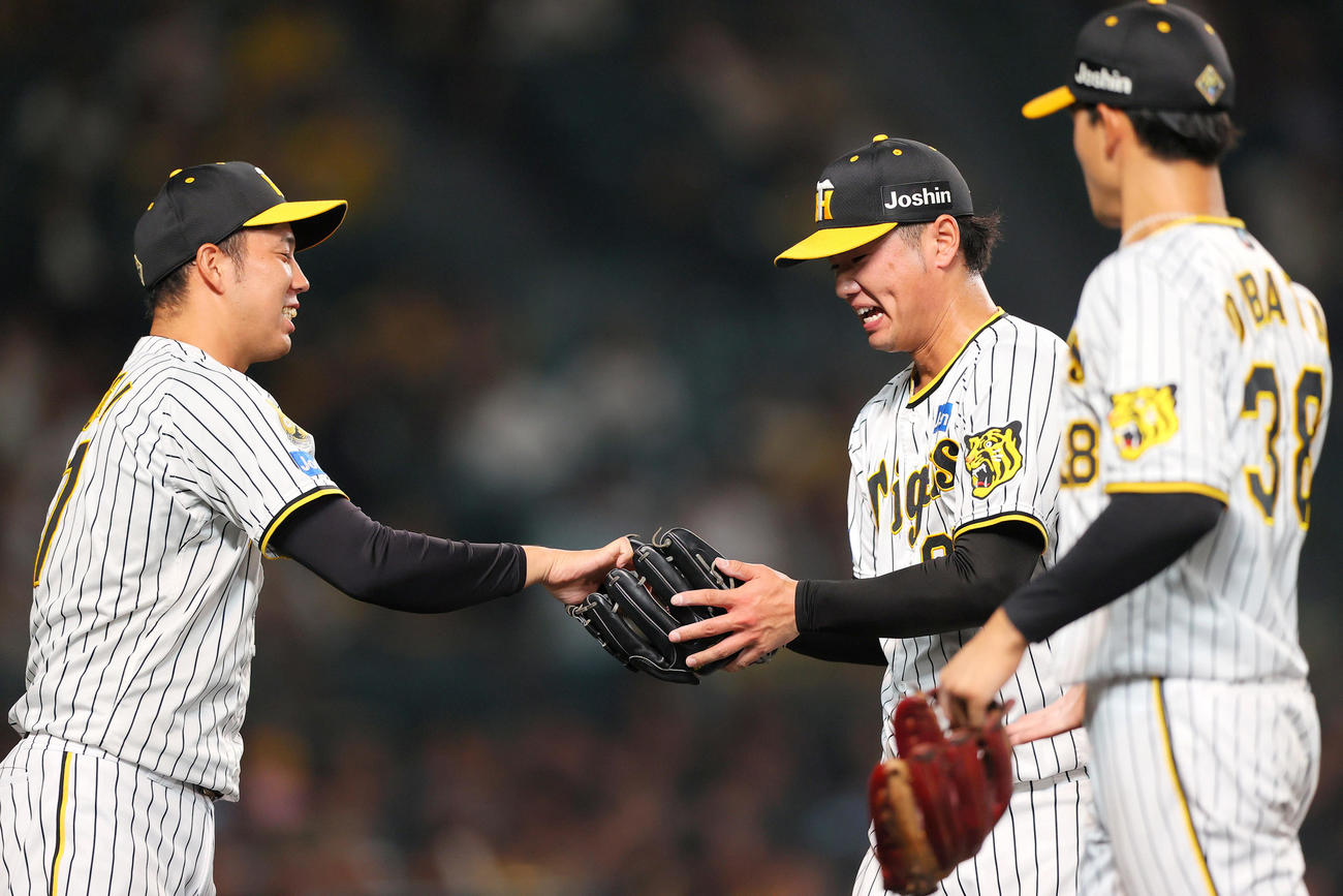 阪神対DeNA 8回表に登板し無失点に終えた阪神川原（中央）は青柳からボールを渡される（撮影・上山淳一）