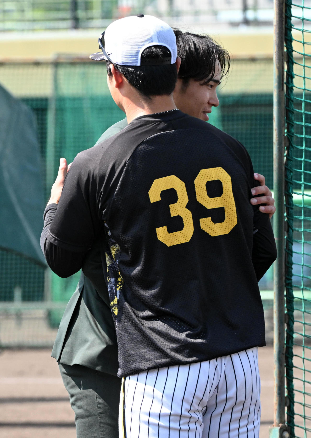 戦力外通告を受けた遠藤（奥）は栄枝とハグ（撮影・前岡正明）
