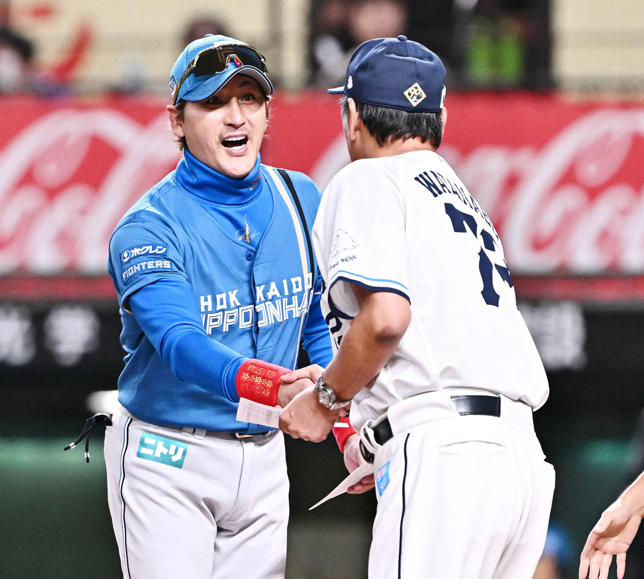 西武対日本ハム　試合前にメンバー表の交換をし握手を交わす日本ハム新庄監督（後方）と西武渡辺GM兼監督代行（撮影・滝沢徹郎）