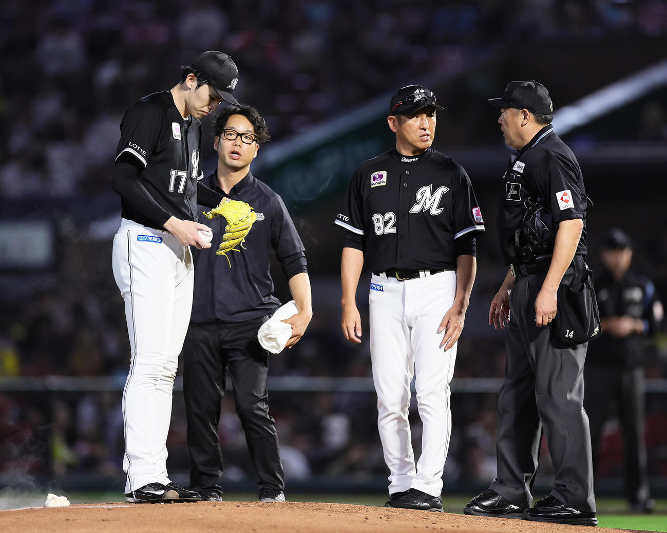 楽天対ロッテ　1回裏楽天2死、辰己に中前打を浴び転倒した佐々木（左端）はスタッフと状態を確認する（撮影・足立雅史）