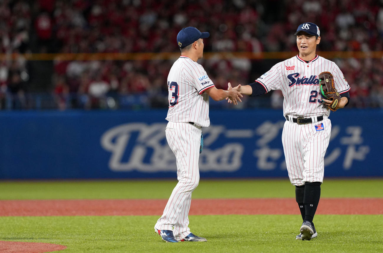 ヤクルト対広島　7回表を終え握手を交わすヤクルト石川（左）と青木（撮影・横山健太）