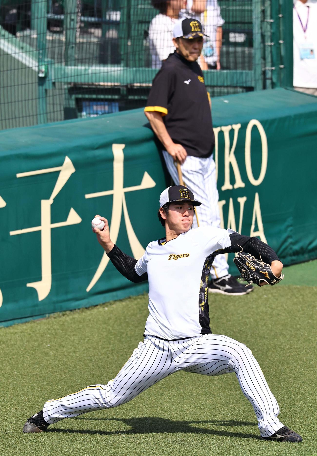 岡田監督（奥）のチェックを受けながらキャッチボールをする石黒（撮影・上田博志）