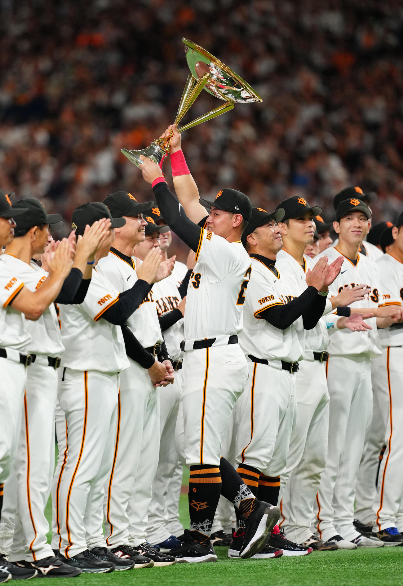 巨人対DeNA　試合後のセレモニーでセ・リーグ優勝トロフィーを掲げる巨人岡本和（中央）（撮影・江口和貴）
