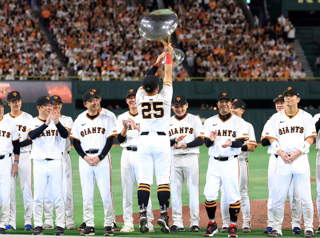 巨人対DeNA　最終戦を勝利で飾り、表彰式で優勝トロフィーをジャンプしてスタンドに見せる巨人岡本和（撮影・浅見桂子）