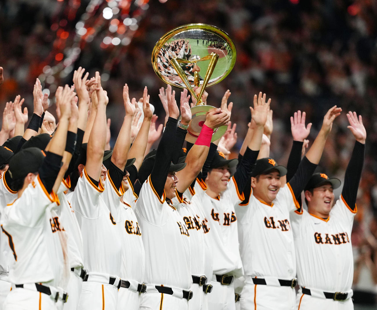 巨人対DeNA　優勝セレモニー後、トロフィーを掲げ、巨人の選手たちと写真に納まる阿部監督（中央）（撮影・江口和貴）