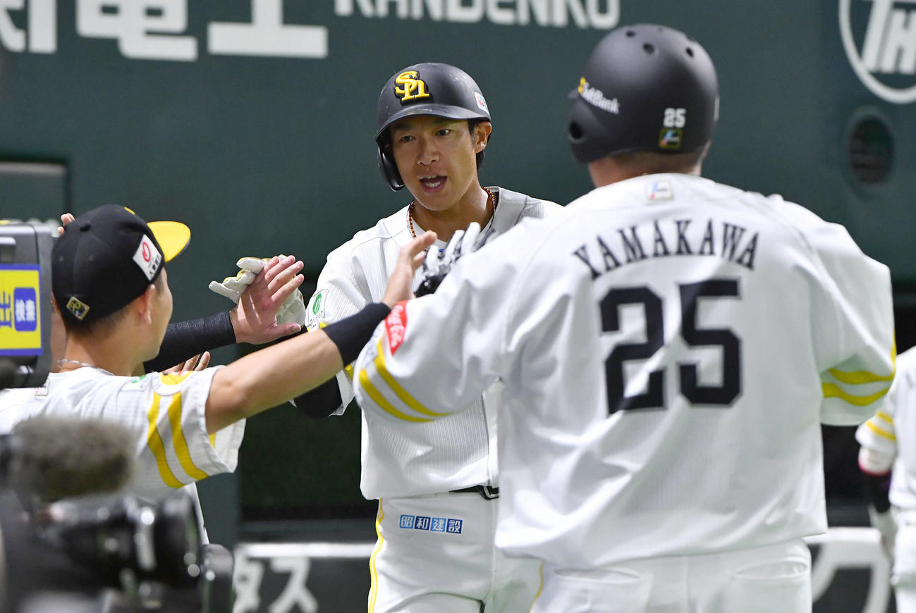 ソフトバンク対楽天　1回裏ソフトバンク無死二、三塁、山川（右）の右犠飛で生還し、タッチを交わす柳田（撮影・岩下翔太）