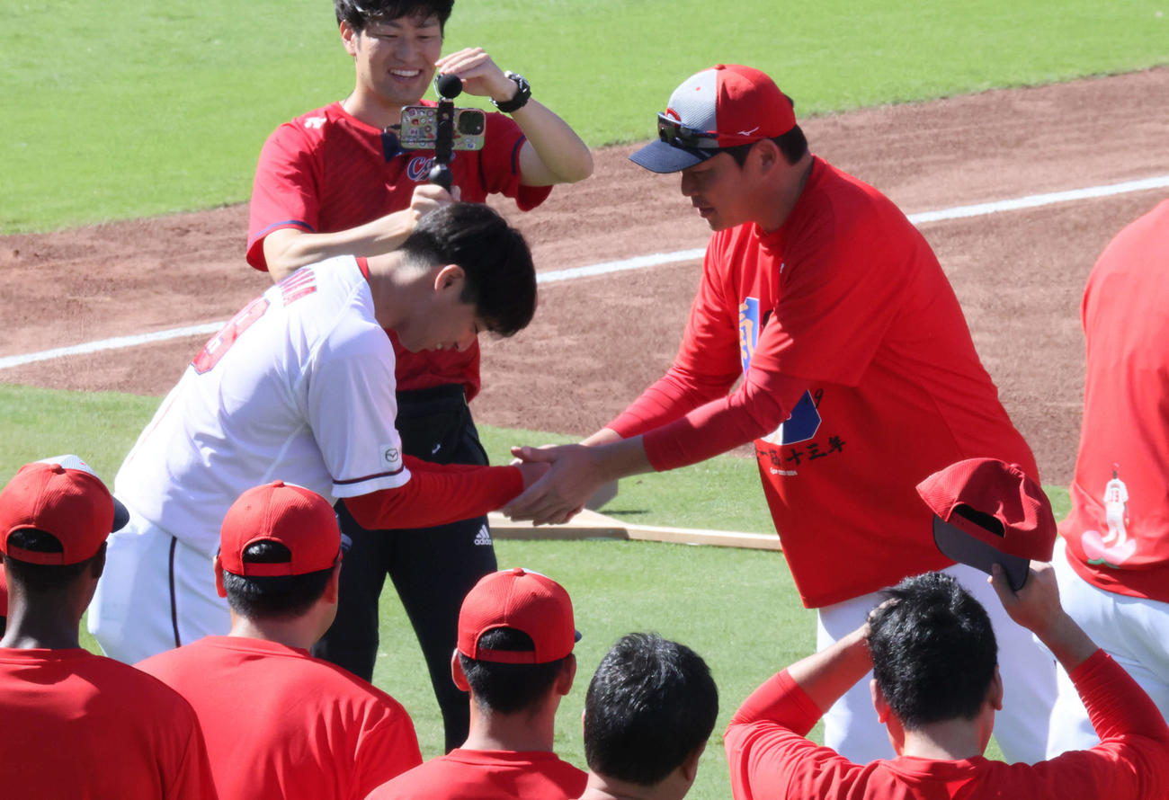 引退会見後、グラウンドで新井監督と握手する広島野村（左）（撮影・加藤孝規）