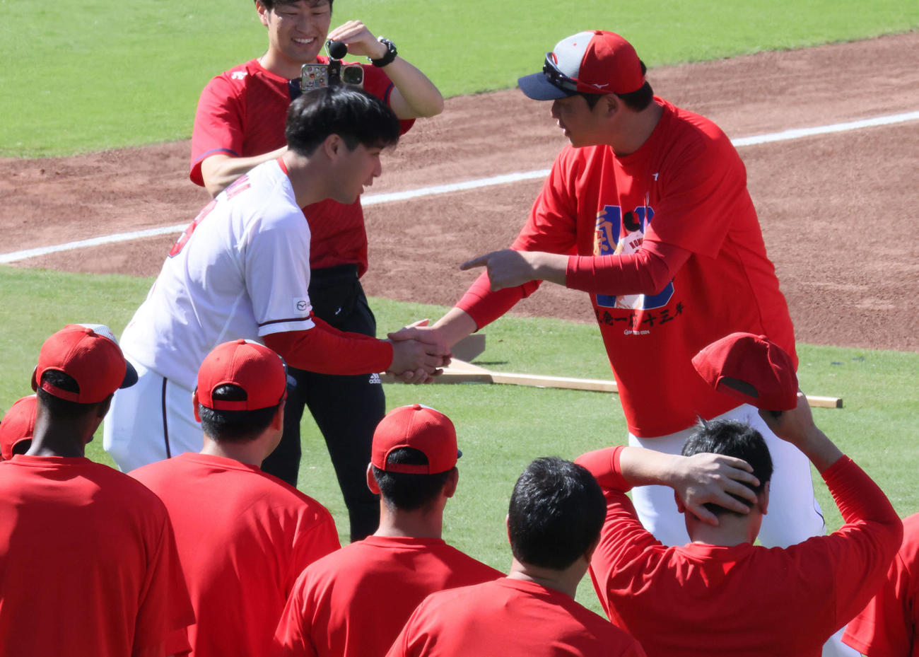 引退会見後、グラウンドで新井監督と握手する広島野村（左）（撮影・加藤孝規）