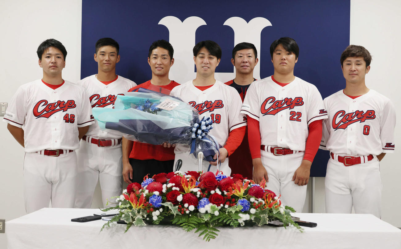 引退会見後、広陵OBと記念写真におさまる広島野村祐輔（中央）。左から河野、中村奨、土生スコアラー、野村、白浜スコアラー、高、上本（撮影・加藤孝規）